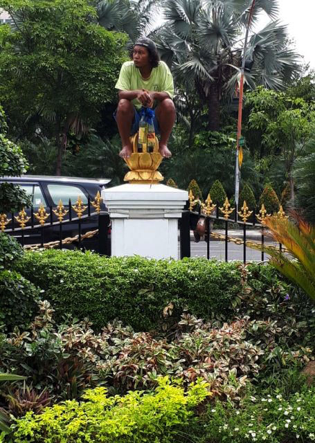 NANGKRING DI PAGAR GRAHADI: Sambil membawa botol berisi bensin, pria yang mengalami gangguan jiwa ini nangkring di atas pagar halaman Grahadi, Surabaya, Satu (6/1) sore.