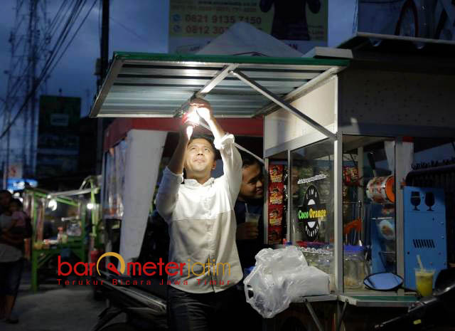 PASANGKAN LAMPU WARUNG PKL: Hari mulai gelap, Emil Dardak memasangkan lampu salah satu warung PKL di Menganti, Gresik, Rabu (23/5). | Foto: Barometerjatim.com/ROY HASIBUAN