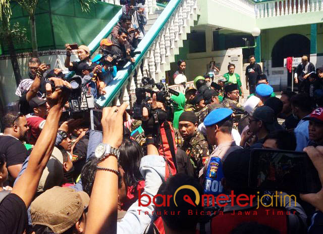 APARAT TURUN MELERAI: Aparat kepolisian melerai bentrok antara anggota Banser dengan massa #2019GantiPresiden di Masjid Kemayoran Surabaya, Minggu (26/8). | Foto: Barometerjatim.com/NANTHA LINTAG