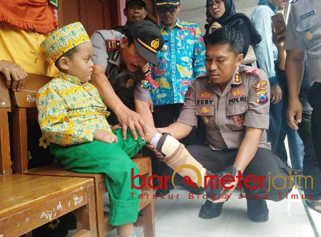 SEMANGAT BERPRESTASI: AKBP Feby DP Hutagalung memasangkan kaki palsu untuk Rizky agar tetap semangat berprestasi. | Foto: Barometerjatim.com/HAMIM ANWAR