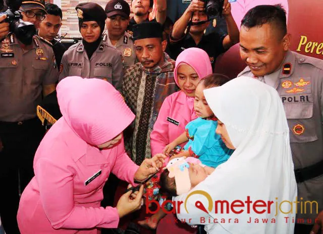 POTONG RANBUT: Prosesi akikah dan potong rambut anak asuh Rochmat yang dilakukan Ibu Bhayangkari, Atik Luki Hermawan. | Foto: Barometerjatim.com/NATHA LINTANG