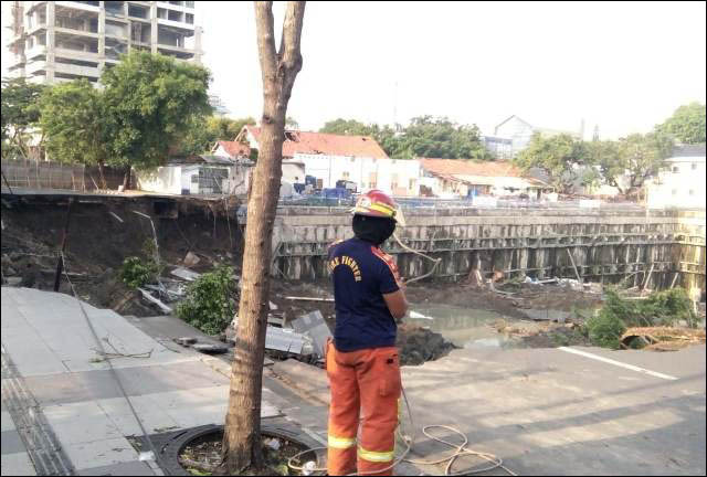 KEDALAMAN 20 METER: Salah seorang petugas di lokasi Jalan Raya Gubeng yang ambles selebar 100 x 30 meter dengan kedalaman 20 meter. | Foto: IST