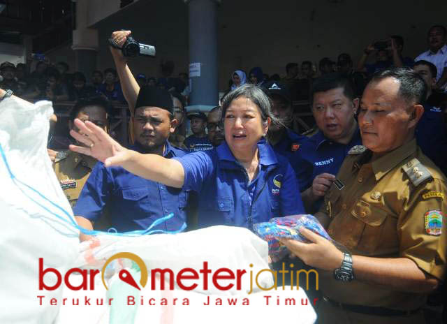 Kakak Jess membongkar bantuan untuk korban tsunami di Lamsel, Senin (7/1). | Foto: Barometerjatim.com/natha lintang