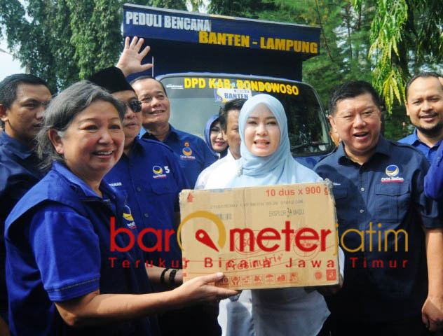 Kakak Jess (kiri) serakan bantuan kepada Bupati Irna Narulita. | Foto: Barometerjatim.com/natha lintang