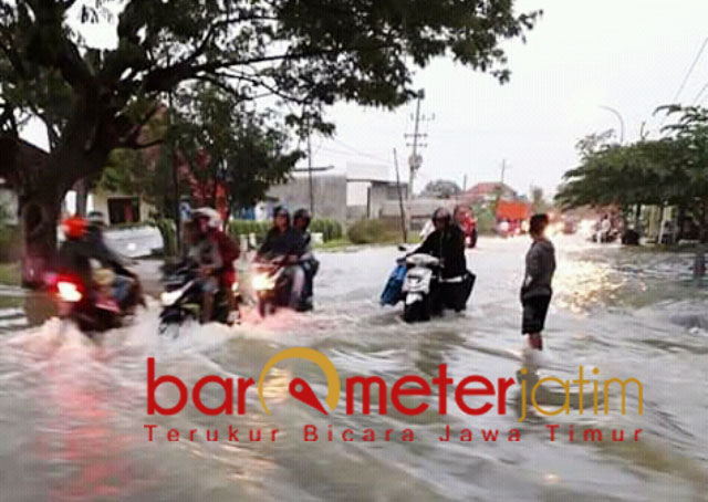 Pengendara motor berjibaku dengan ketinggian air saat banjir di Gresik. | Barometerjatim.com/didik hr