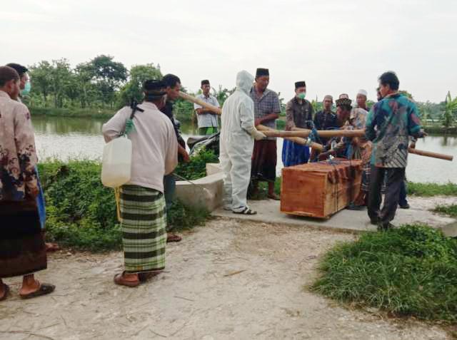 WARGA LAMONGAN: Jenazah PDP Corona saat hendak dimakamkan di kawasan Kecamatan Turi, Lamongan. | Foto: IST