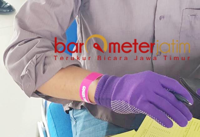 SCREENING BERLAPIS: Gelang penanda untuk TKI asal Jatim yang pulang dari Malaysia. | Foto: Barometerjatim.com/ROY HS