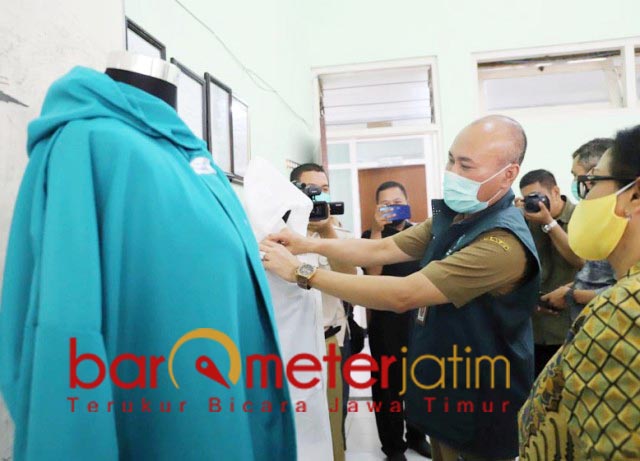 CEGAH CORONA: Wahid Wahyudi, melihat baju hazmat produksi siswa SMKN 6 Surabaya. | Foto: Barometerjatim.com/ROY HS