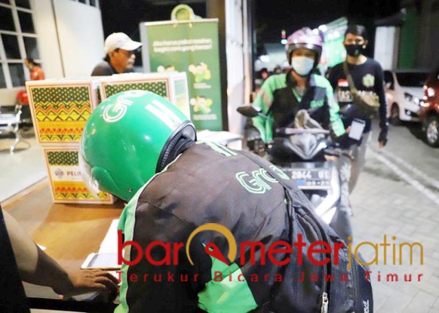 PAKET SEMBAKO: Para driver Ojol ambil paket sembako untuk distribusikan ke warga terdampak Corona. | Foto: Barometerjatim.com/ROY HS