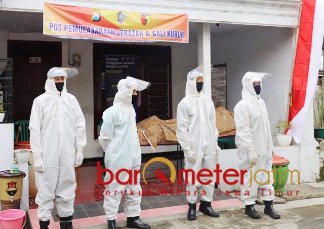 SIAGA: Petugas lengkap dengan baju hazmat di depan rumah pemulasaraan jenazah. | Foto: Barometerjatim.com/ROY HS