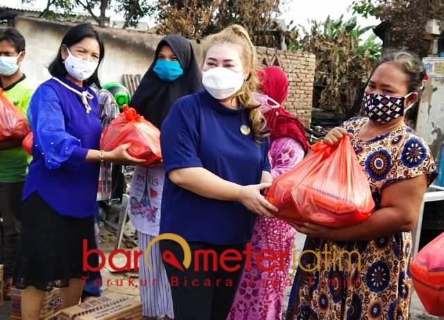 BANTU WARGA: Maria Lucia membantu warga RW VI Tambak Asri, Morokrembangan, korban kebakaran. | Foto: Barometerjatim.com/ROY HS
