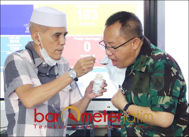 MINUM LANGSUNG: Dokter I Dewa Gede Nalendra disuapi Habib Hasan Mulachela probiotik. | Foto: Barometerjatim.com/ROY HS