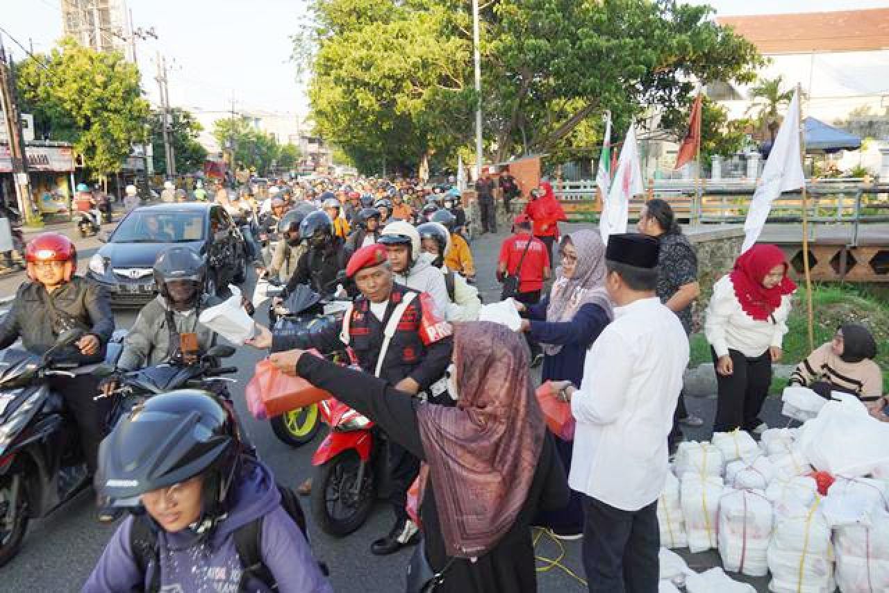 ANTUSIAS: Pengendara yang melintas antusias menerima paket takjil dari PDIP Jatim. | Foto: IST