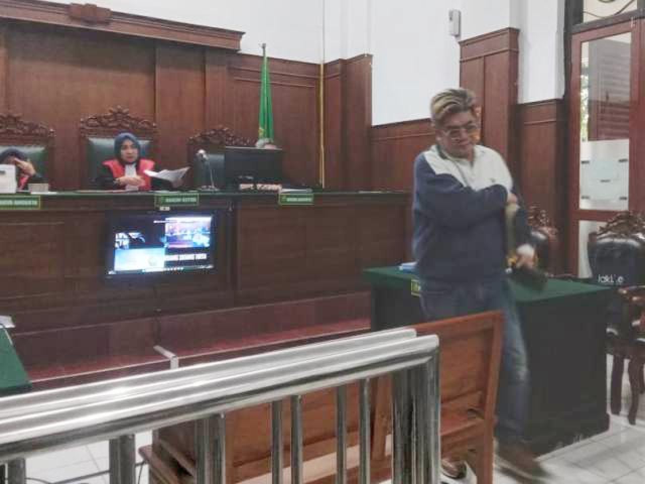 PERKARAKAN ISTRI: Benjamin Kristianto tinggalkan ruang sidang dengan terdakwa istrinya. | Foto: IST