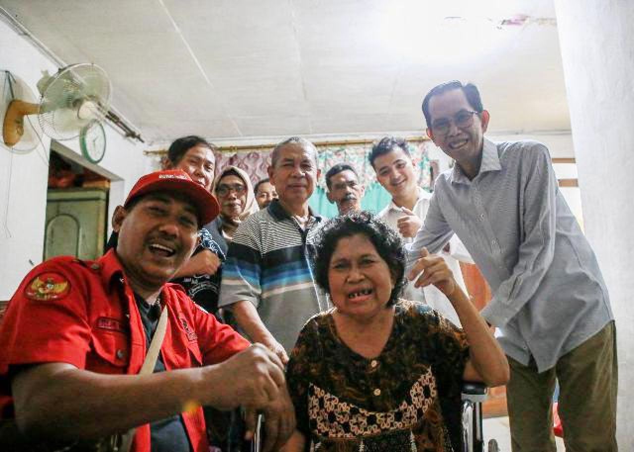 ULURKAN BANTUAN: Adi Sutarwijono beri bantuan kursi roda kepada salah seorang warga. | Foto: IST