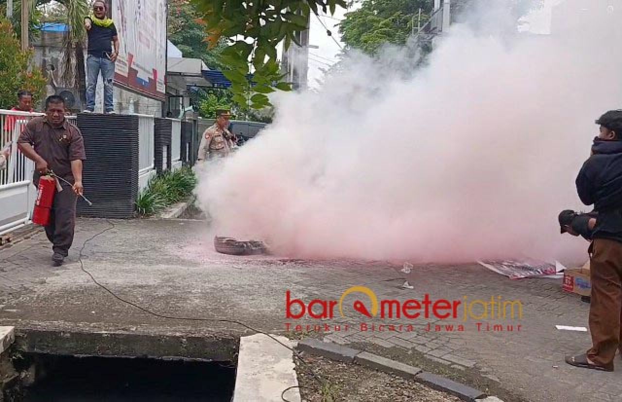 NGACIR: Seorang keamanan gedung langsung ngacir usai semprotkan Apar. | Foto: Barometerjatim.com/BKT