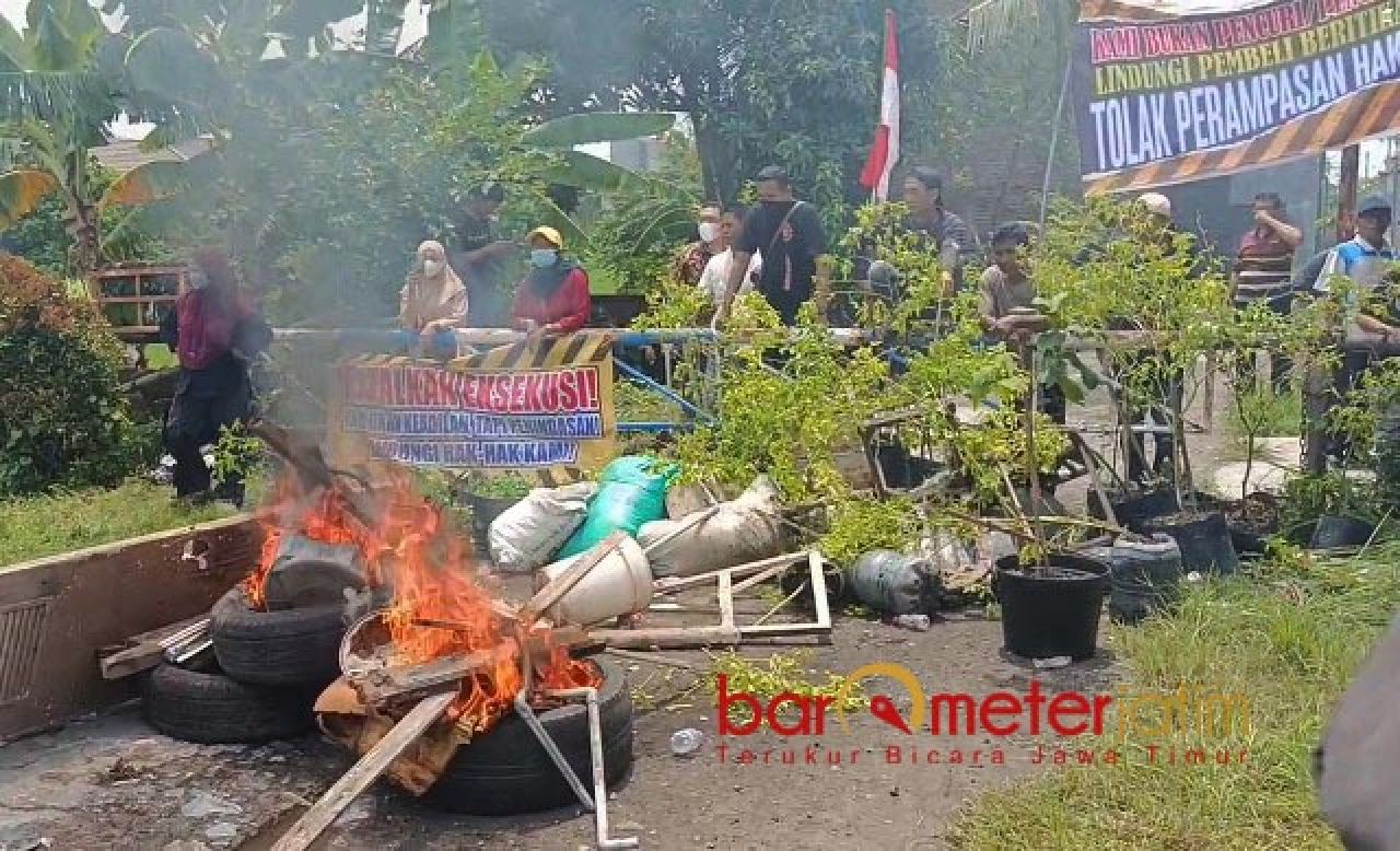 SEMPAT MELAWAN: Penghuni sempat melawan menolak tempat tinggalnya dieksekusi. | Foto: Barometerjatim.com/RQ