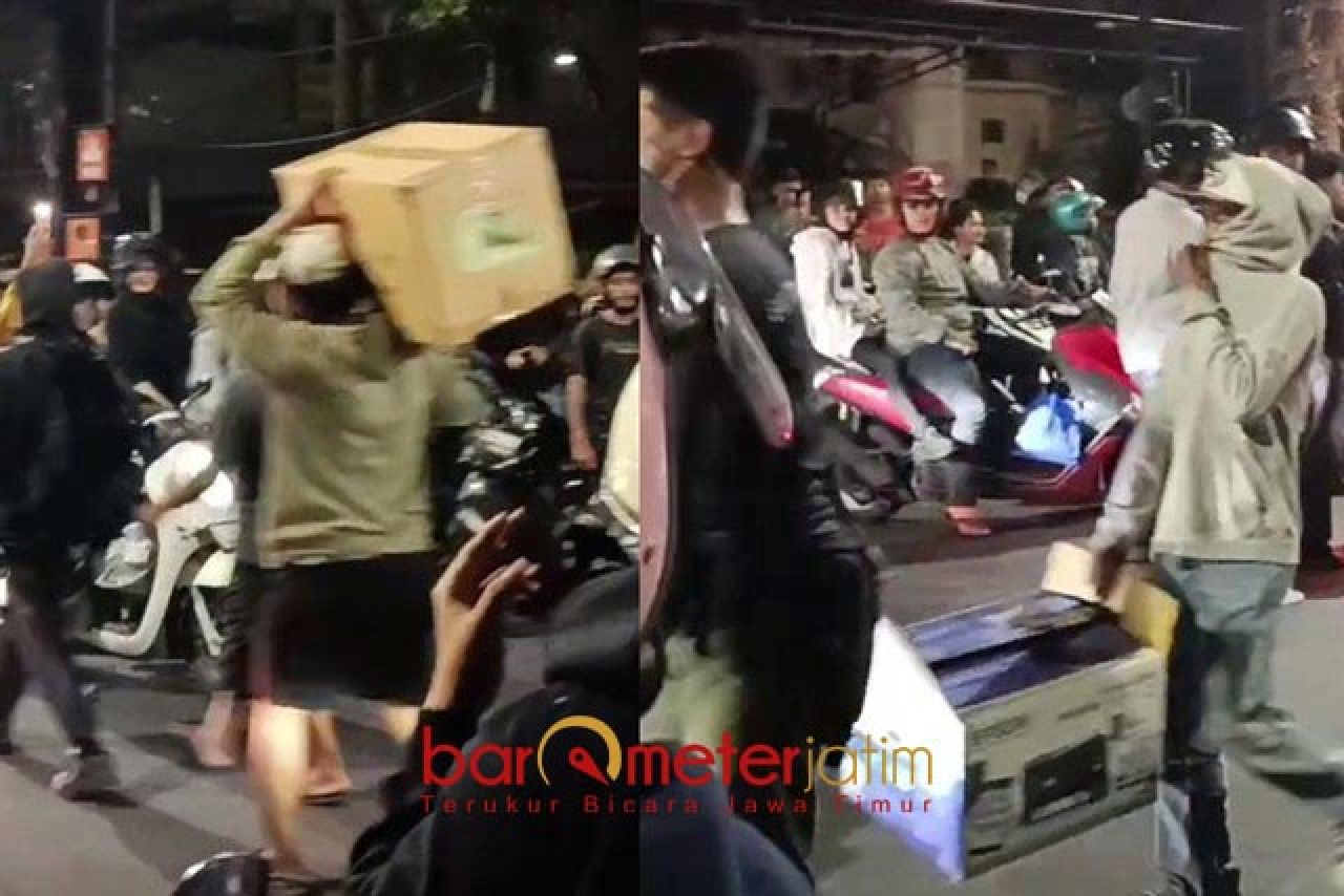 JARAHAN: Sejumlah orang sibuk mengamankan barang jarahannya dari Grahadi. | Foto: Barometerjatim.com/BKT