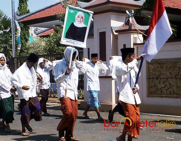 SANTRI DUKUNG BU NYAI: Tak hanya Warga Muslimat NU, santri di Pamekasan juga mengusung poster Khofifah saat pawai taaruf peringatan Hari Santri Nasional, Minggu (22/10). | Foto: Barometerjatim.com/ROY HASIBUAN