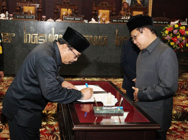 PEMANTAUAN ORANG ASING: Gubernur Soekarwo (kiri) bersama Ketua DPRD Jatim, Halim Iskandar menandatangani persetujuan Raperda tentang pemantauan orang asing. | Foto: Ist
