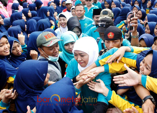 BEREBUT SALAMAN: Dengan kawalan Banser, Khofifah Indar Parawansa meladeni dengan ramah serbuan massa jalan sehat untuk bersalaman. | Foto: Barometerjatim.com/MARIJAN AP