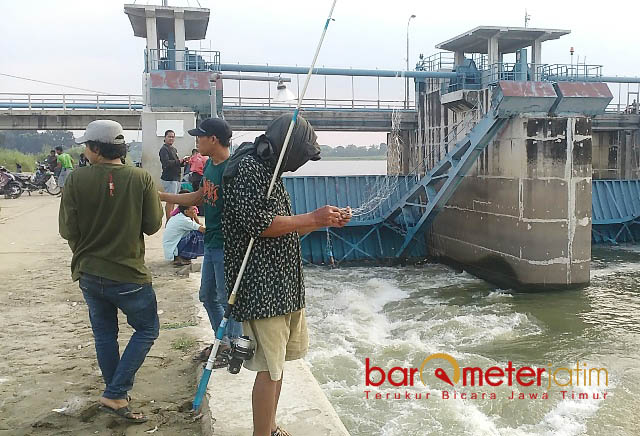 MANCING GRATIS: Pengunjung bebas menikmati hobi memancing secara gratis di sepanjang tepian sungai kawasan Babat Barrage. | Foto: Barometerjatim.com/HAMIM ANWAR