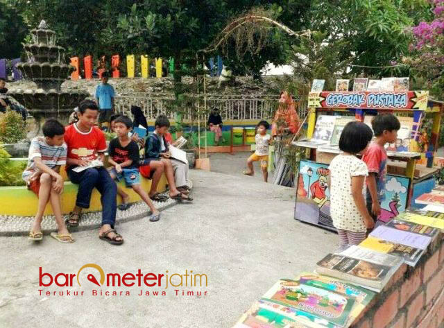 TAMAN KENDALIFORNIA: Pengunjung bisa bermain dan bersantai ria sambil membaca buku yang tersedia di Gerobak Pustaka. | Foto: Barometerjatim.com/HAMIM ANWAR