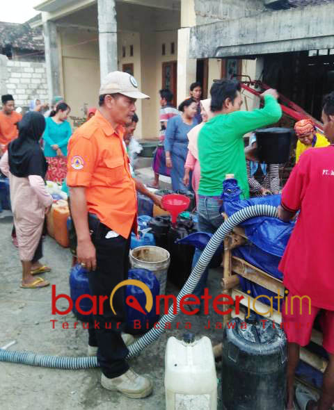 DROPPING AIR: Kasi Tanggap Darurat BPBD Lamongan, Muslimin memimpin dropping air bersih kepada warga. | Foto: Barometerjatim.com/HAMIM ANWAR