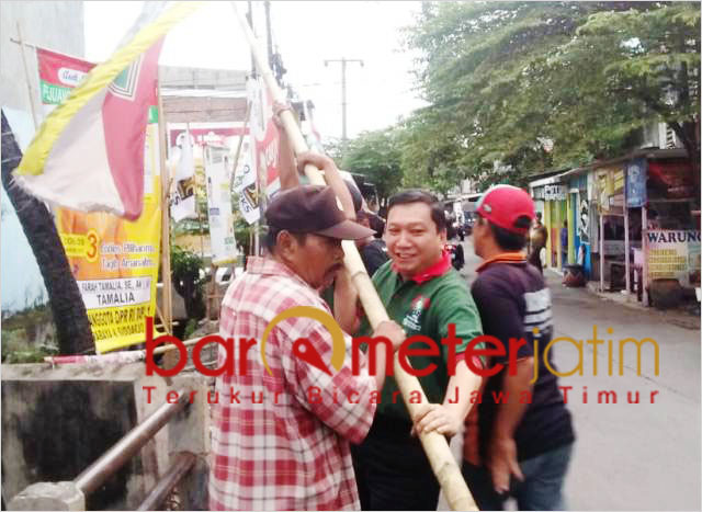 Fandi Utomo mendapat bantuan dari masyarakat saat menurunkan APK. | Foto: Barometerjatim.com/roy hs