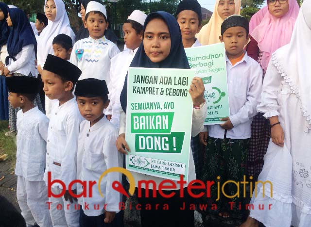 Bocah polos ini membawa pesan damai untuk Kampret dan Cebong agar kembali bersatu. | Foto: Barometerjatim.com/natha lintang