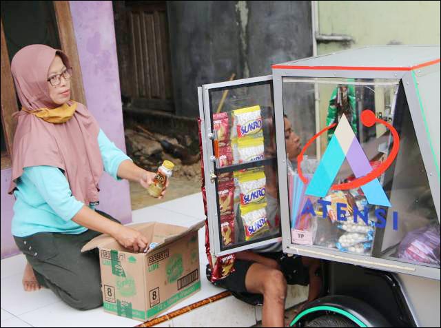 KASIH IBU: Ibu Gading membantu anaknya merapikan barang dagangan sebelum berangkat. | Foto: Kemensos/IST