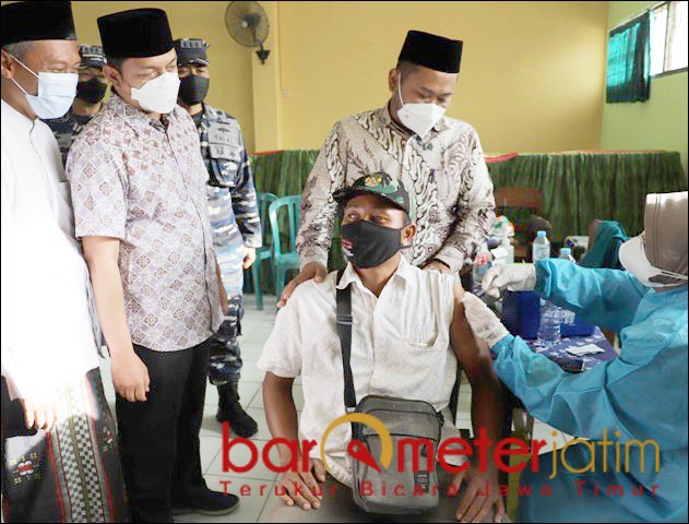 KEHANGATAN BUPATI: Gus Yani memegang pundak peserta vaksinasi di Ponpes Al Karimi Grasik. | Foto: Barometerjatim.com/ROY HS